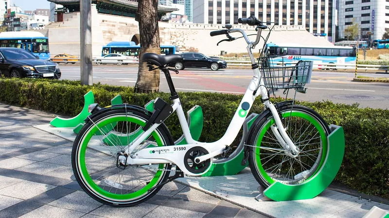 A current QR-type 'New Ddareungi' returned to its rack. The black box under the saddle is the smart lock; to return, dock it and push the lever down over the rear wheel. The five digits on the chain guard (31590 here) are the bike number.