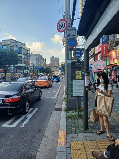 A bus stop pole: the stop name, the 정류소 ID (stop ID) beneath it, then a route diagram for each service that calls here. The yellow notice asks you not to board carrying coffee or other drinks.