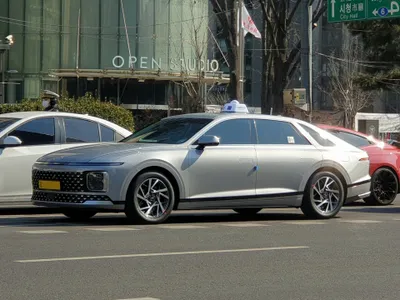 A current-shape taxi by City Hall. Seoul taxis come in several body colours; what identifies them is the roof light and the yellow commercial plate.