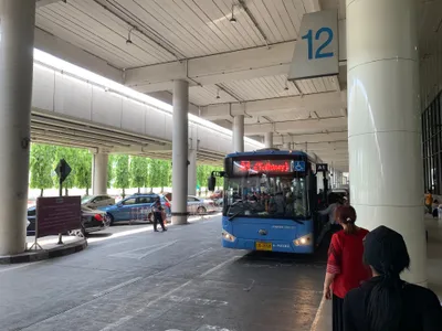 The bus bay at Don Mueang — queue where the “A1” sign hangs