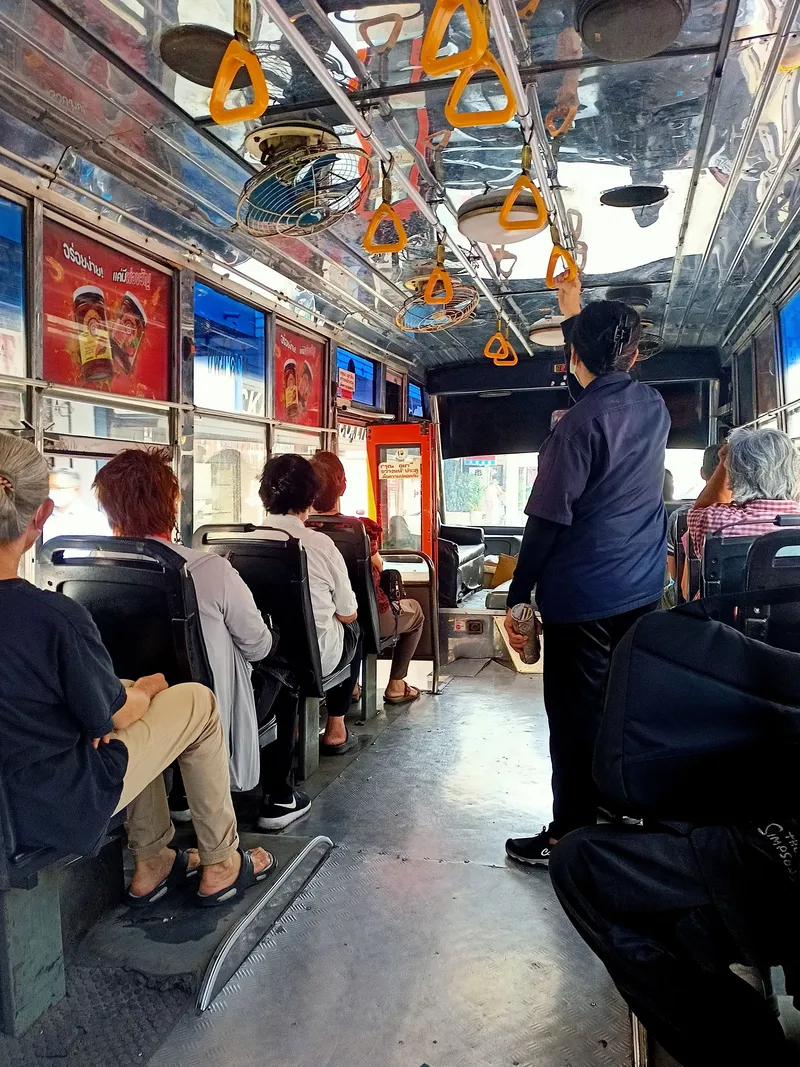 The conductor works the aisle with a steel fare tube — tell them your destination and pay cash