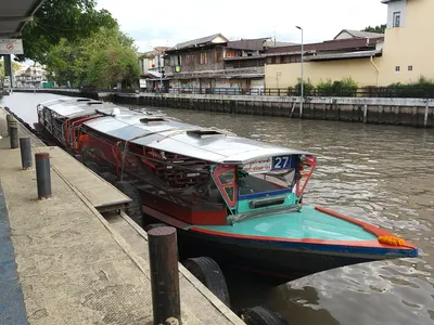 A Saen Saep canal boat — the sheet hanging from the roof edge is the splash guard