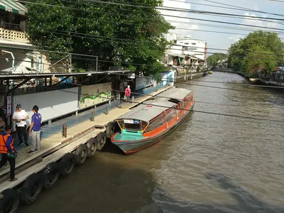 A canal boat pier — boats pull in alongside a narrow walkway along the bank
