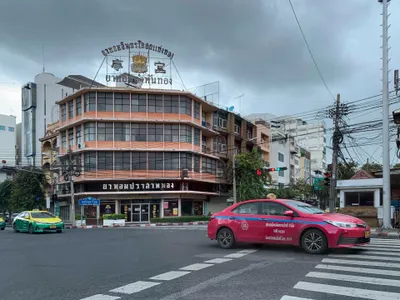 Bangkok taxis come in several colours — a pink one and a green-and-yellow one here