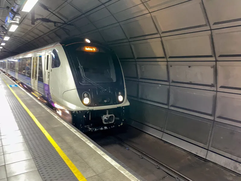 An Elizabeth line train pulling into Heathrow's underground platform, showing 'Heathrow T4'