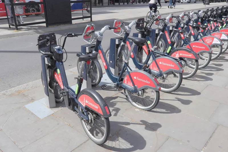 The red panel on the bike reads 'Unlimited 60 minute rides for £3.50 a day' — the day-pass terms, printed on the bike