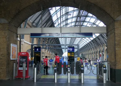 The gateline at an intercity terminus — once the indicator overhead reads 'Platform 3 / Edinburgh / Boarding', go through these gates to the platform