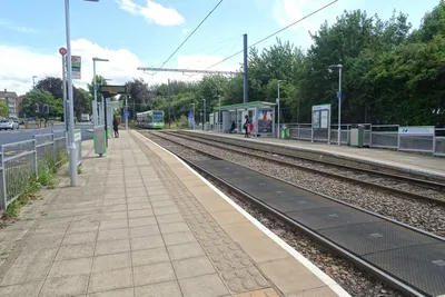 A suburban tram stop — there are no gates; you step straight from the platform onto the tram