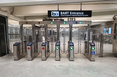 BART fare gates at Civic Center station — the round blue target on top is where you tap