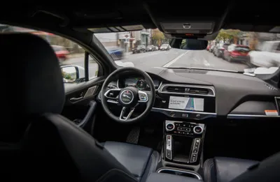 Inside a Waymo while it drives — the driver's seat is empty and the dash shows the arrival time